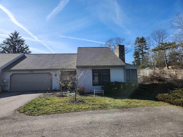 view of front of home with a garage, driveway, a chimney, and a shingled roof