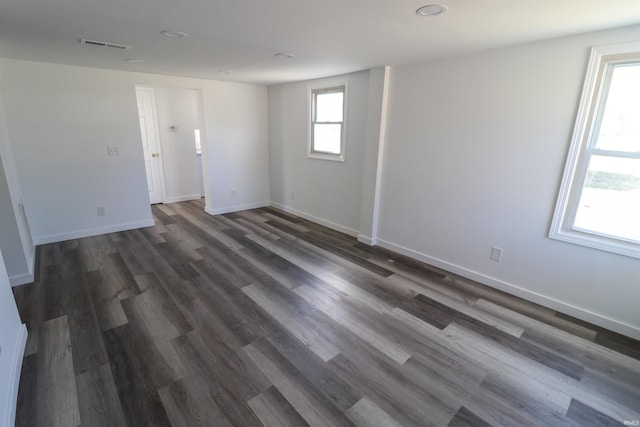 unfurnished room with recessed lighting, visible vents, dark wood finished floors, and baseboards