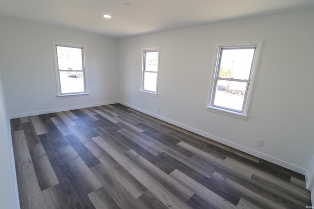 empty room with recessed lighting, dark wood-style flooring, and baseboards