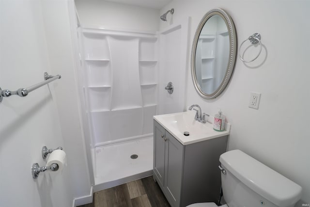 full bathroom with toilet, wood finished floors, a shower stall, and vanity