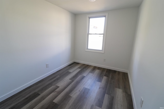 empty room featuring dark wood-style floors and baseboards