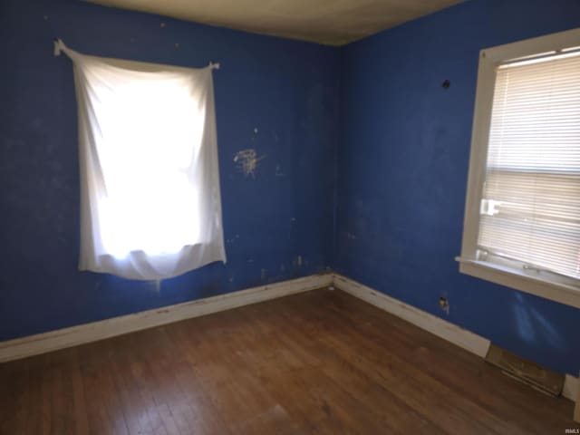 empty room featuring baseboards and wood finished floors