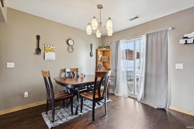 dining area with a chandelier, wood finished floors, visible vents, and baseboards