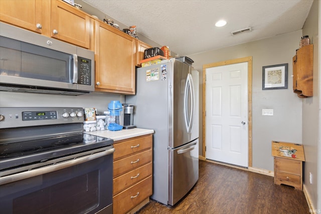 kitchen featuring visible vents, dark wood finished floors, appliances with stainless steel finishes, light countertops, and a textured ceiling