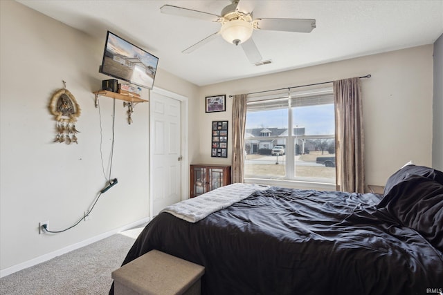 carpeted bedroom featuring a ceiling fan, visible vents, and baseboards