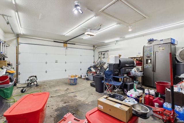 garage with a garage door opener and stainless steel fridge