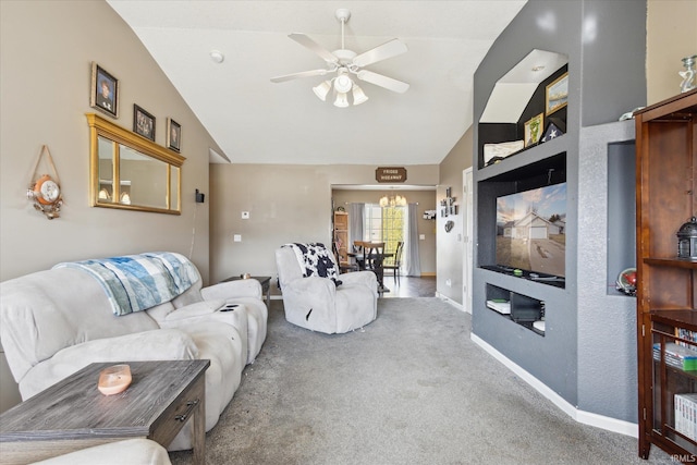 living area featuring carpet floors, vaulted ceiling, baseboards, and ceiling fan with notable chandelier