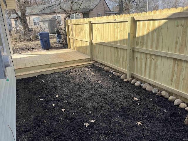 view of yard featuring an outdoor structure, fence, and a storage shed