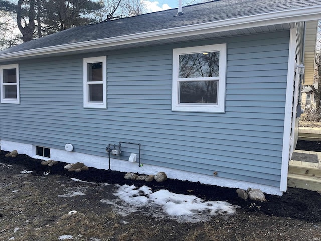 view of home's exterior with roof with shingles