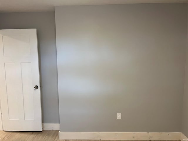 empty room featuring light wood-type flooring and baseboards