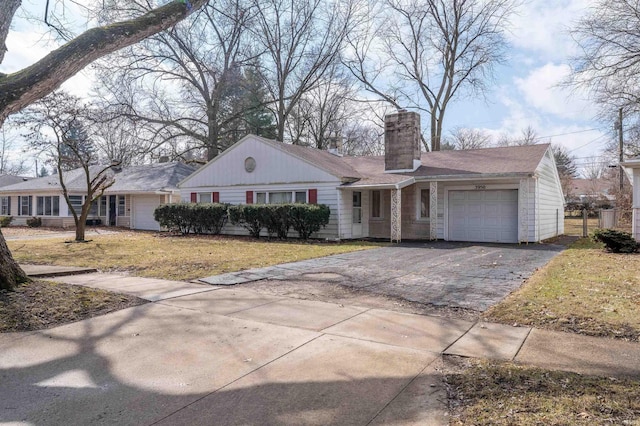 ranch-style house with aphalt driveway, a chimney, an attached garage, and a front lawn