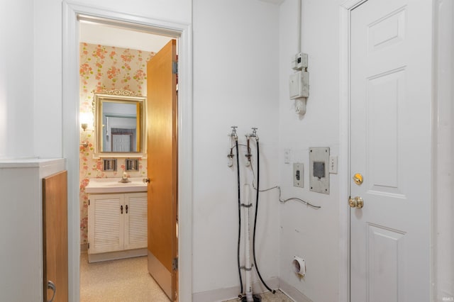 bathroom featuring vanity and wallpapered walls