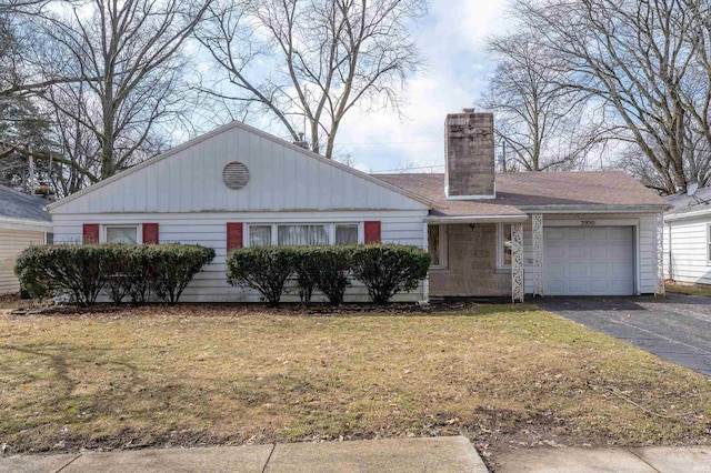 ranch-style home with a garage, aphalt driveway, a chimney, and a front yard