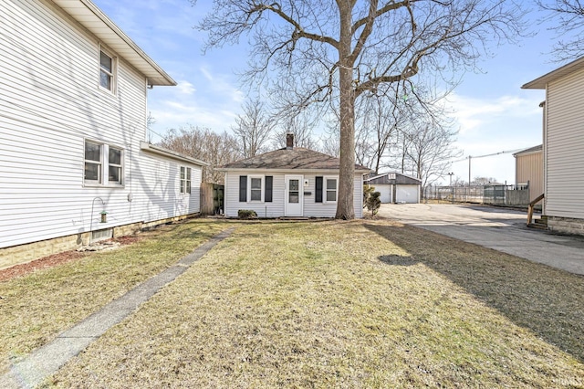 view of yard with a garage, an outbuilding, and fence