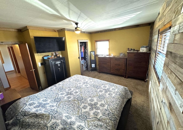 bedroom featuring a textured ceiling, a ceiling fan, a spacious closet, a closet, and carpet