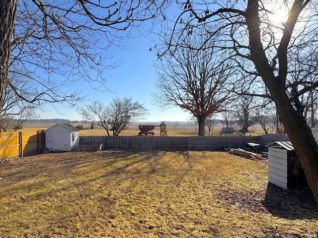 view of yard with a shed, an outdoor structure, and a fenced backyard