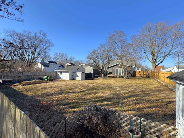 view of yard with a fenced backyard, a shed, and an outdoor structure