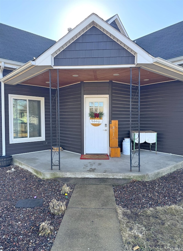 entrance to property with a shingled roof