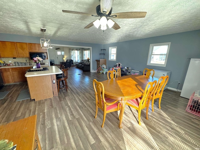 dining space featuring plenty of natural light, baseboards, and wood finished floors