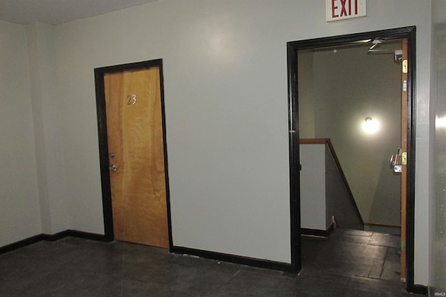 hall featuring baseboards and an upstairs landing