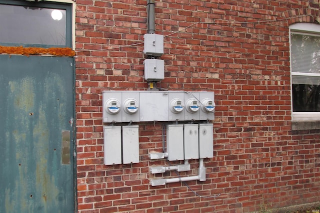 exterior details featuring electric meter and brick siding