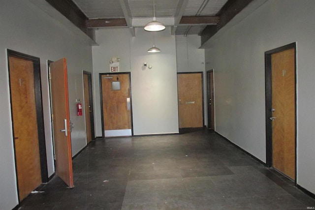 hall with beamed ceiling and a towering ceiling