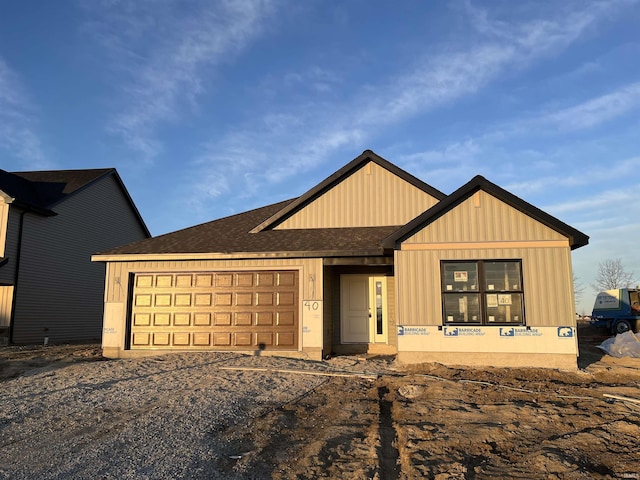 view of front of house with a garage and a shingled roof