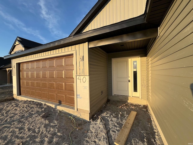 property entrance with a garage and board and batten siding