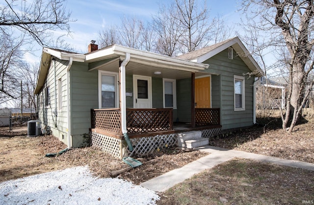 bungalow featuring a porch, central AC, and a chimney