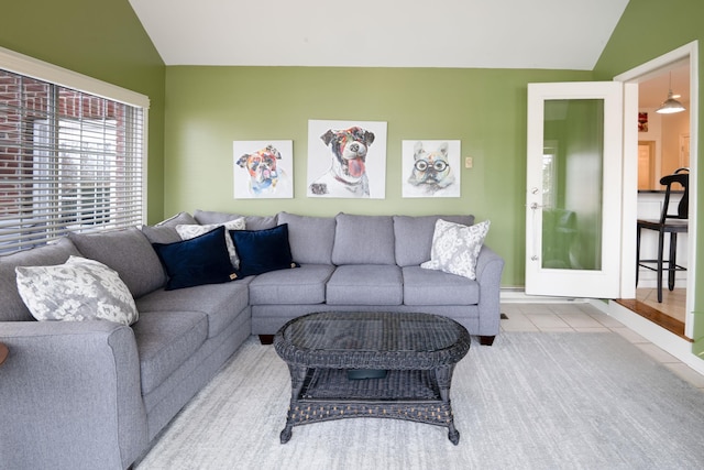 living area featuring lofted ceiling and tile patterned floors