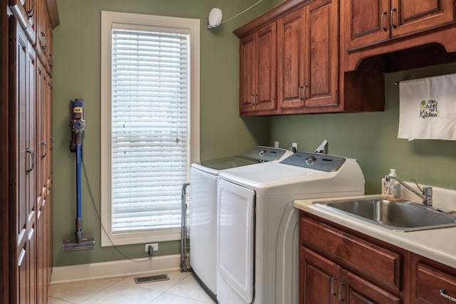 washroom featuring light tile patterned floors, separate washer and dryer, a sink, visible vents, and cabinet space