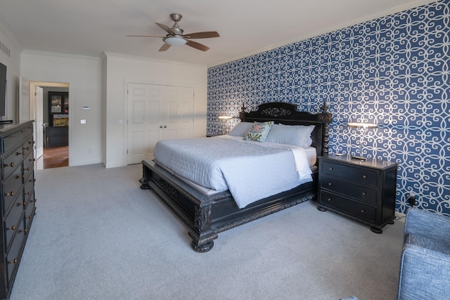 bedroom featuring ceiling fan, carpet floors, baseboards, ornamental molding, and a closet