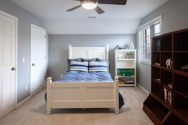 bedroom with lofted ceiling, ceiling fan, visible vents, and light colored carpet