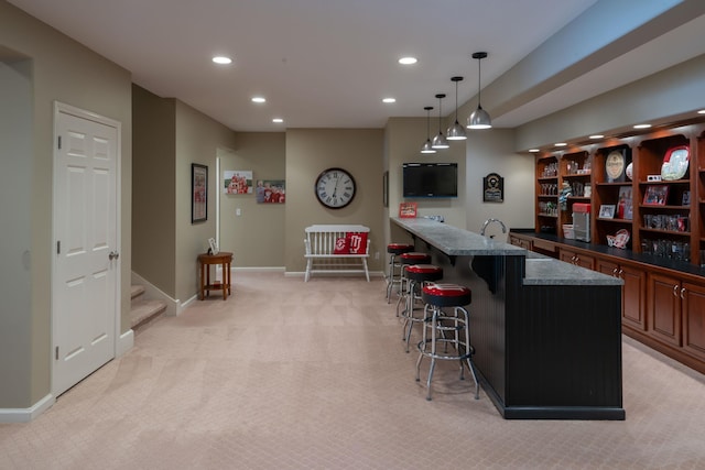 bar with baseboards, light colored carpet, wet bar, pendant lighting, and recessed lighting