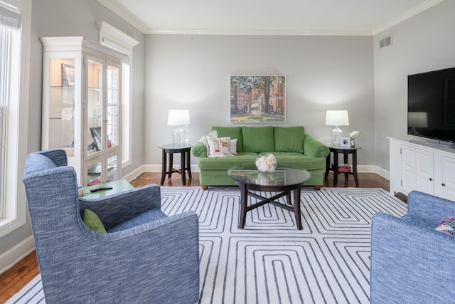 living room featuring ornamental molding, a wealth of natural light, visible vents, and wood finished floors