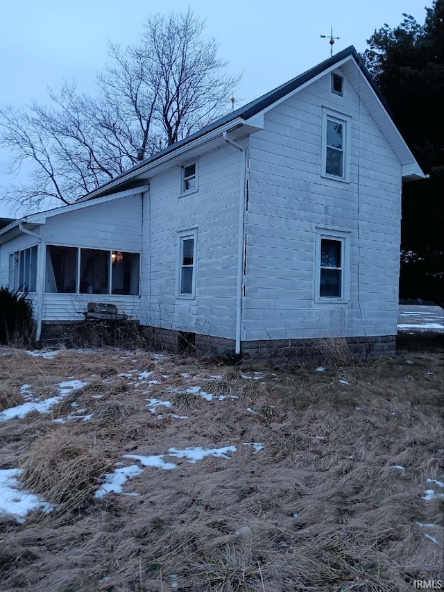 view of snow covered exterior with a sunroom