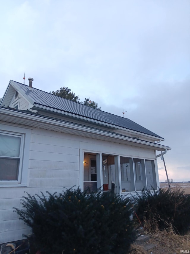 view of front of home featuring a sunroom and metal roof