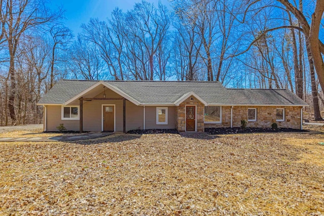 ranch-style house with stone siding and a shingled roof