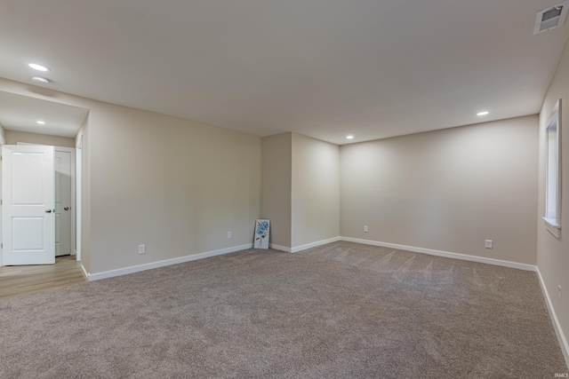 spare room featuring carpet floors, baseboards, visible vents, and recessed lighting