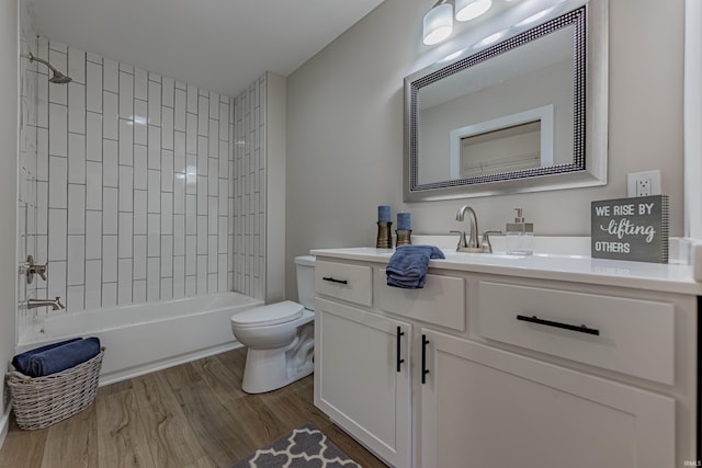 bathroom featuring toilet,  shower combination, wood finished floors, and vanity