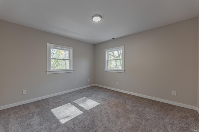 unfurnished room featuring carpet and baseboards