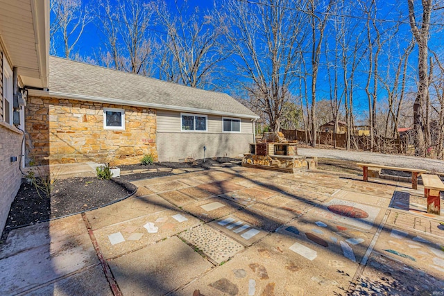 view of patio / terrace with a fireplace and fence