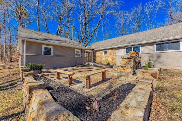 rear view of property featuring a patio area and brick siding