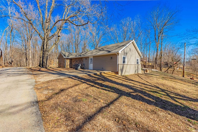 view of home's exterior with a lawn and driveway