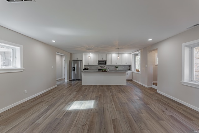 kitchen with light wood-type flooring, white cabinetry, visible vents, and stainless steel appliances