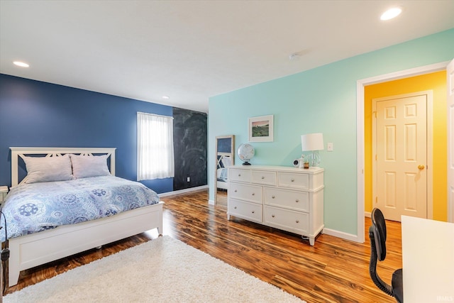 bedroom with recessed lighting, wood finished floors, and baseboards