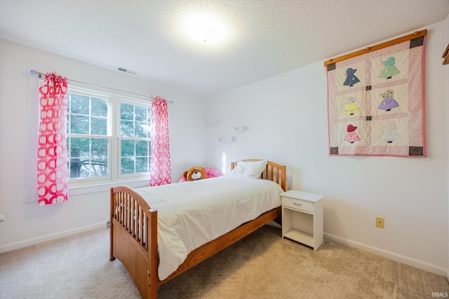 bedroom with visible vents, light carpet, a textured ceiling, and baseboards