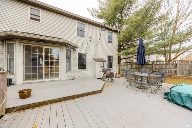 wooden deck with outdoor dining space and fence