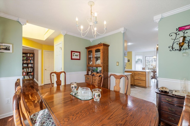 dining room featuring baseboards, light wood-style floors, an inviting chandelier, and crown molding