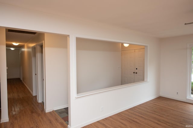 spare room featuring baseboards and wood finished floors